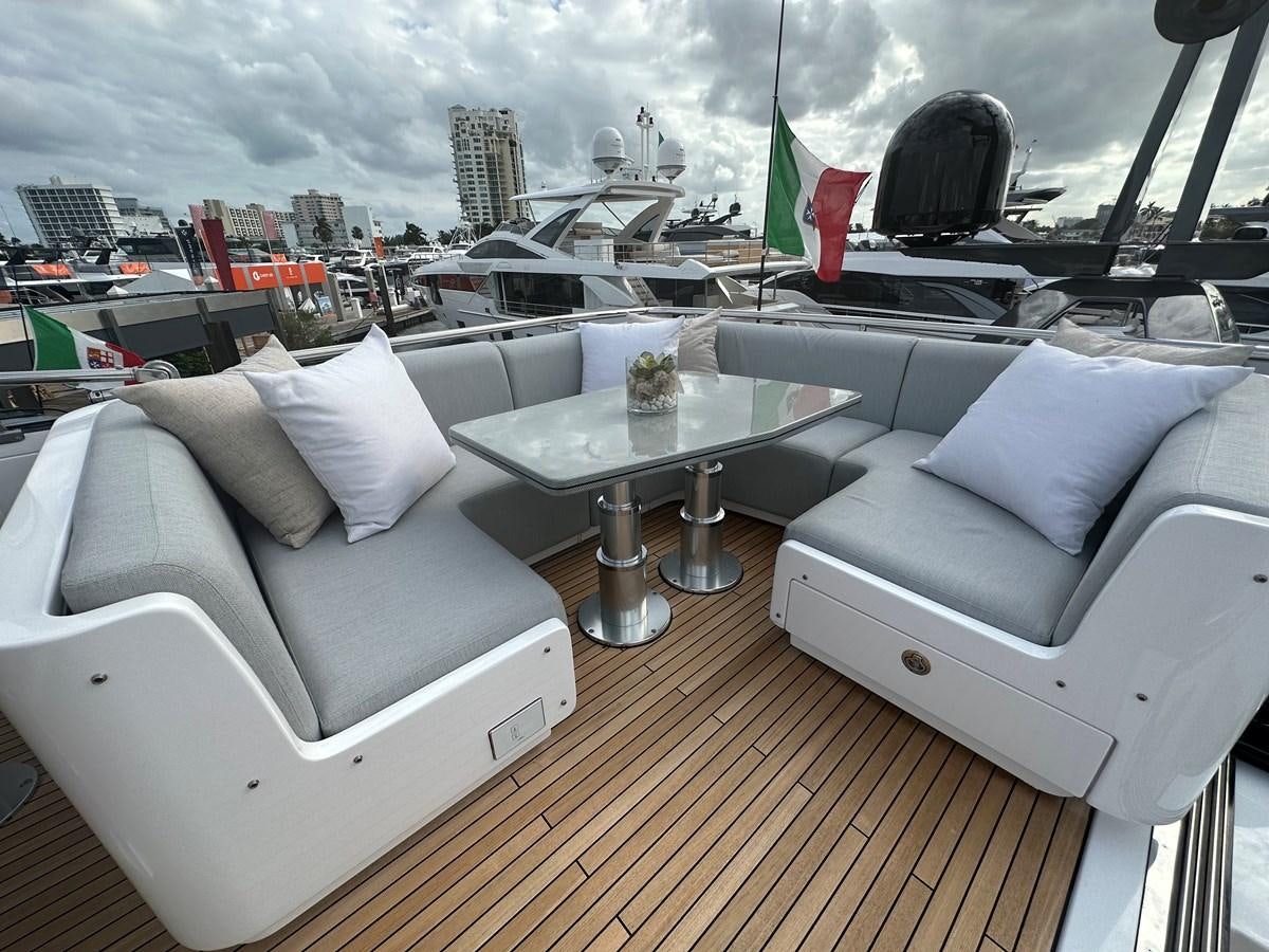 a room with a couch and a table with chairs and a cityscape in the background aboard SUNSET 8 Yacht for Sale