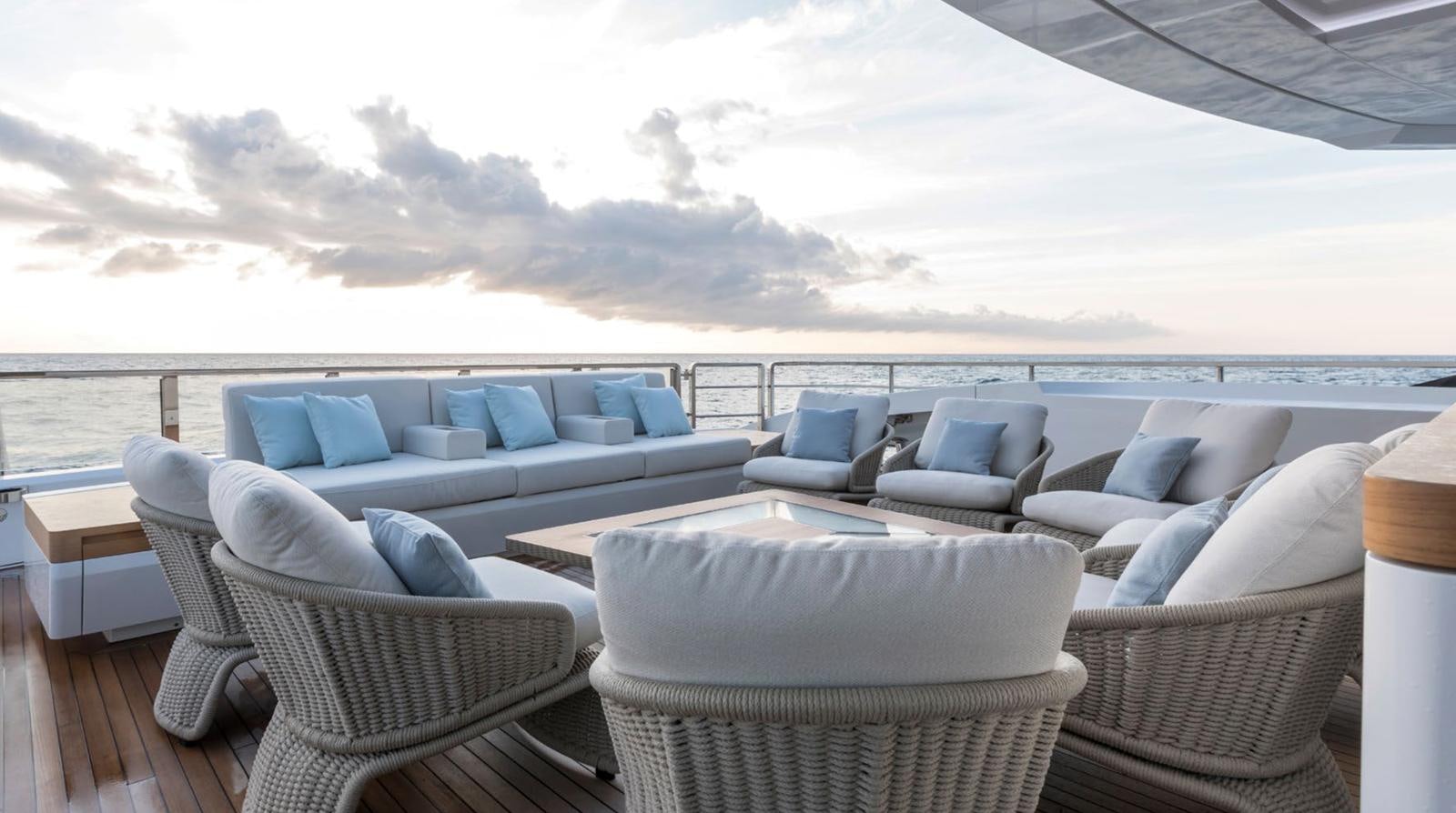 a large white lounge chair on a deck overlooking a large body of water aboard GOLDENEYE Yacht for Sale