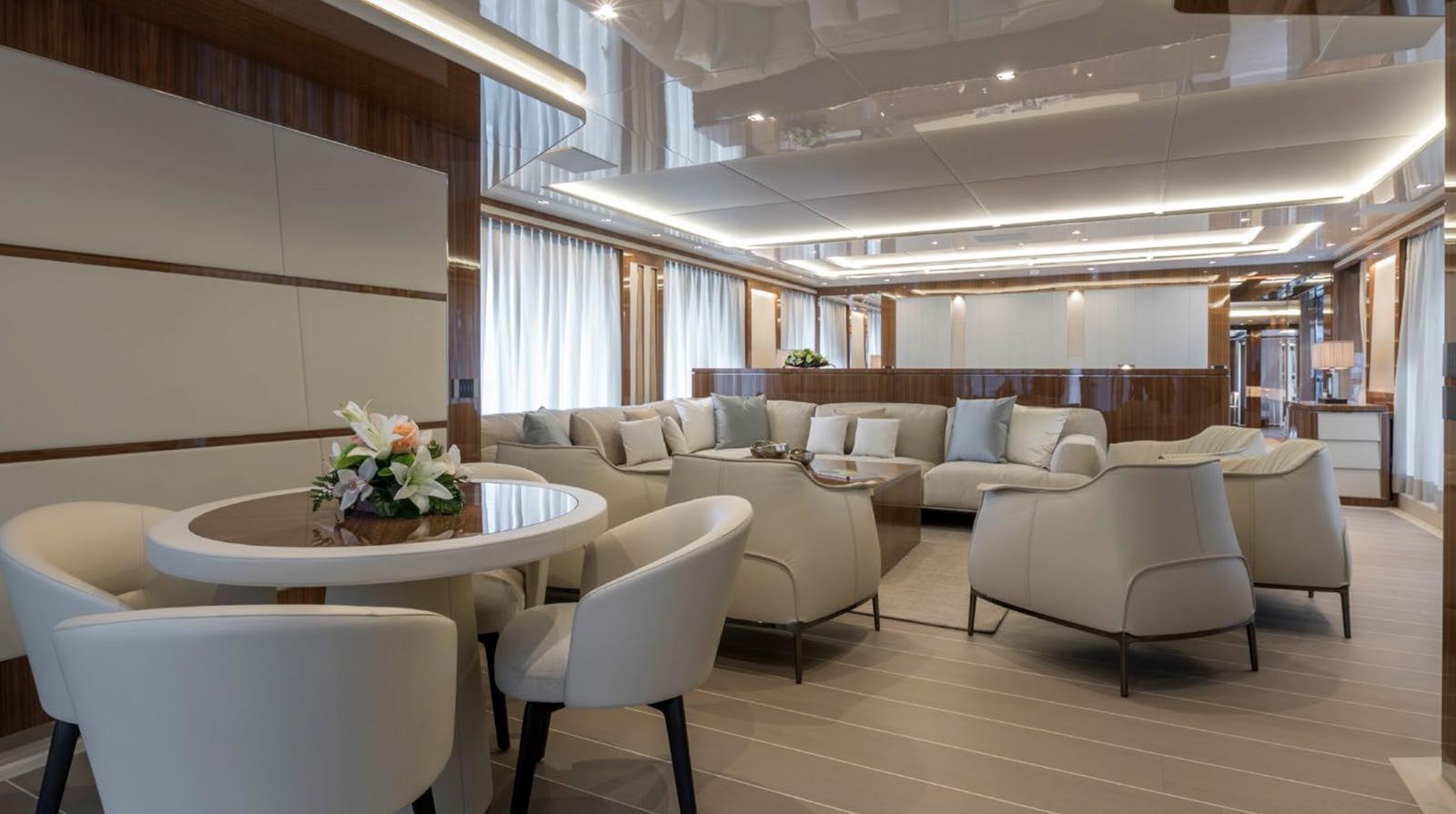a living room with a table and chairs aboard GOLDENEYE Yacht for Sale