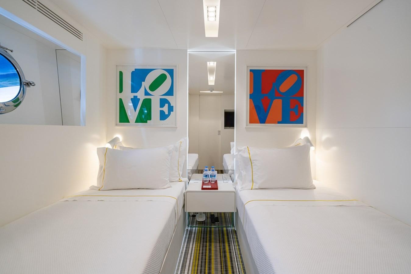 a room with white beds and a painting on the wall aboard ESOSH Yacht for Sale