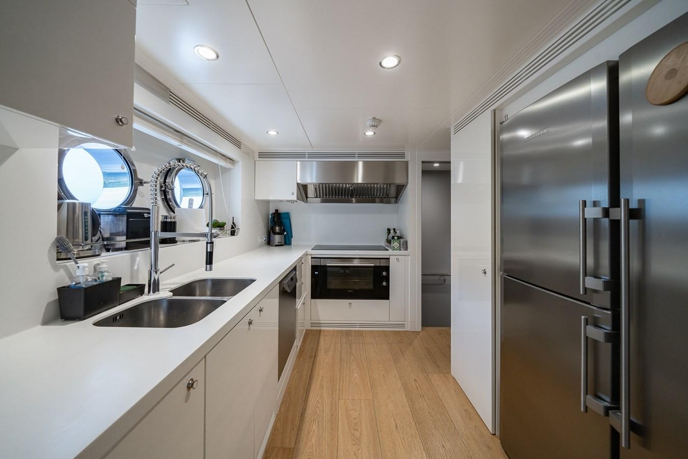 a kitchen with a stainless steel refrigerator aboard ESOSH Yacht for Sale