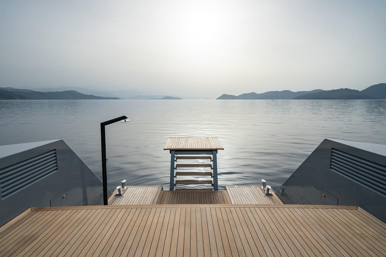 a dock with a lamp post and a body of water in the background aboard ESOSH Yacht for Sale