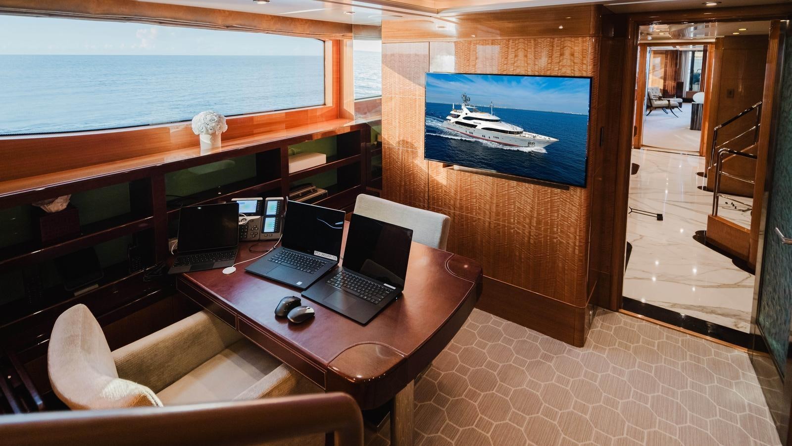 a room with a laptop and a television on the wall aboard GROOVER Yacht for Sale