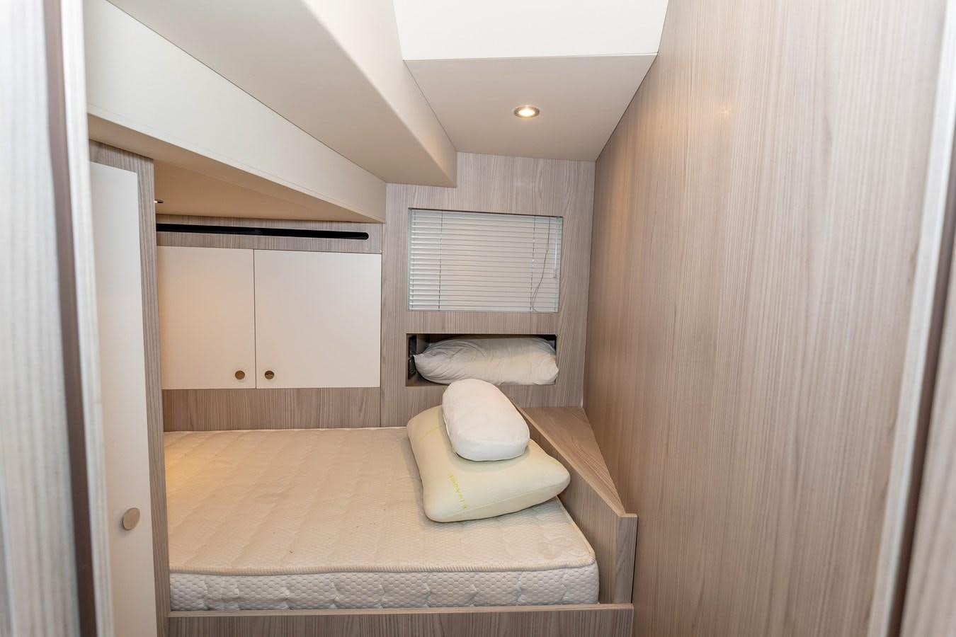 a bedroom with a bed and a window aboard BREEZE Yacht for Sale