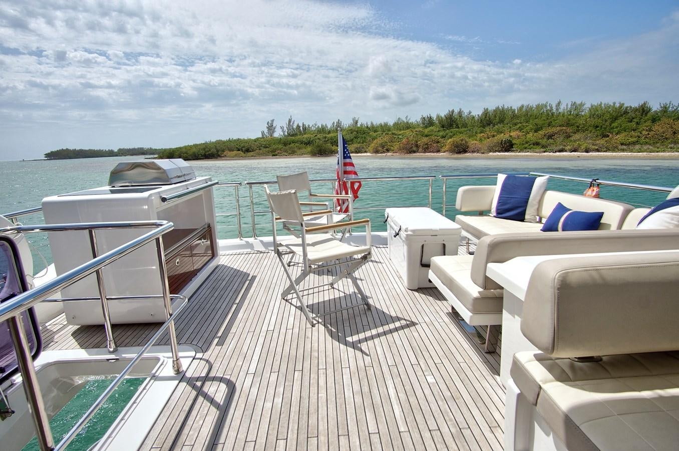 a deck with chairs and a flag on it aboard GRATITUDE Yacht for Sale