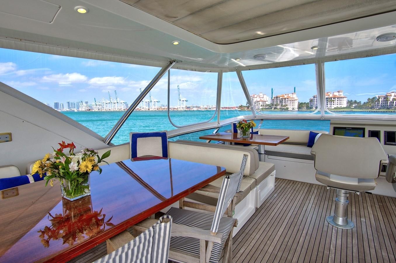 a room with a table chairs and flowers on the table aboard GRATITUDE Yacht for Sale