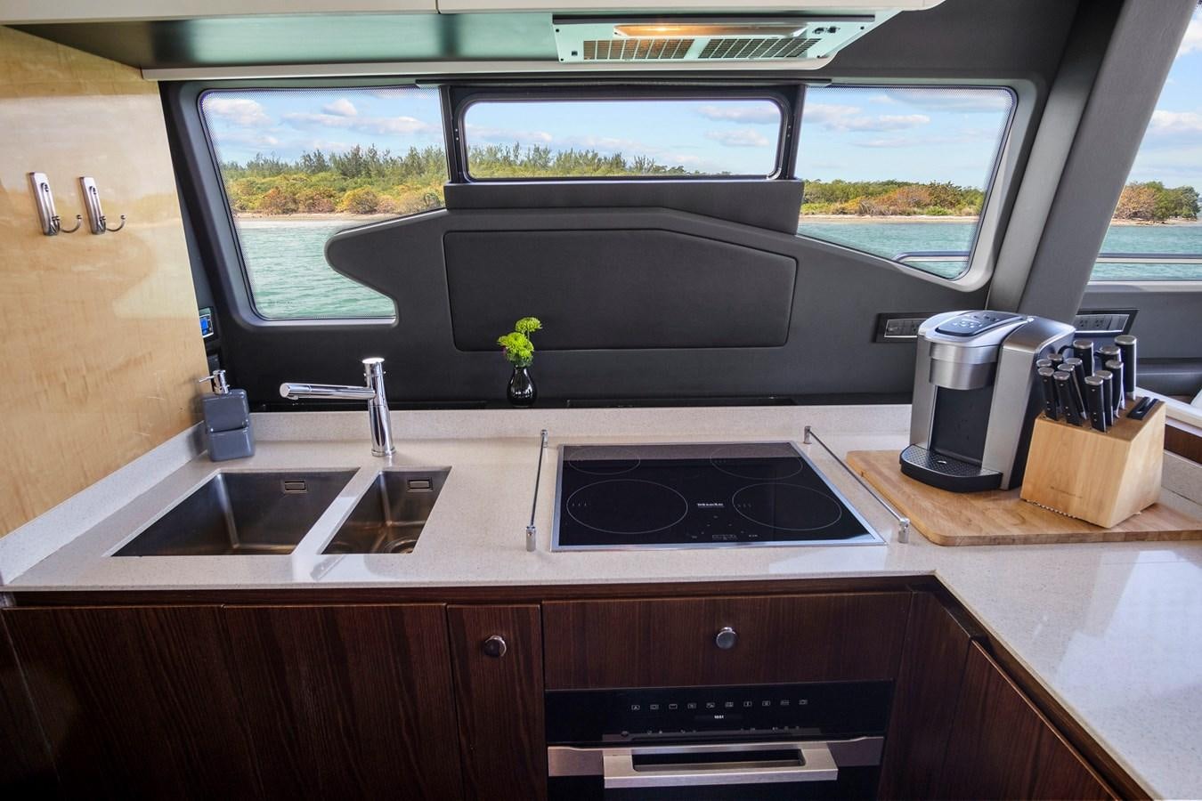 a kitchen with a microwave oven and a window aboard GRATITUDE Yacht for Sale