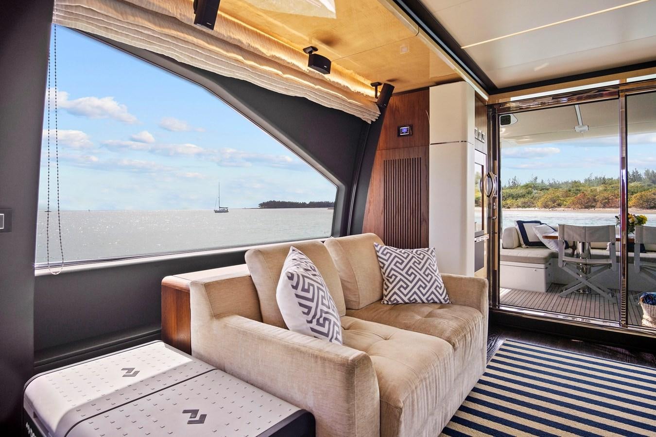a couch and a table in a room with a large window aboard GRATITUDE Yacht for Sale