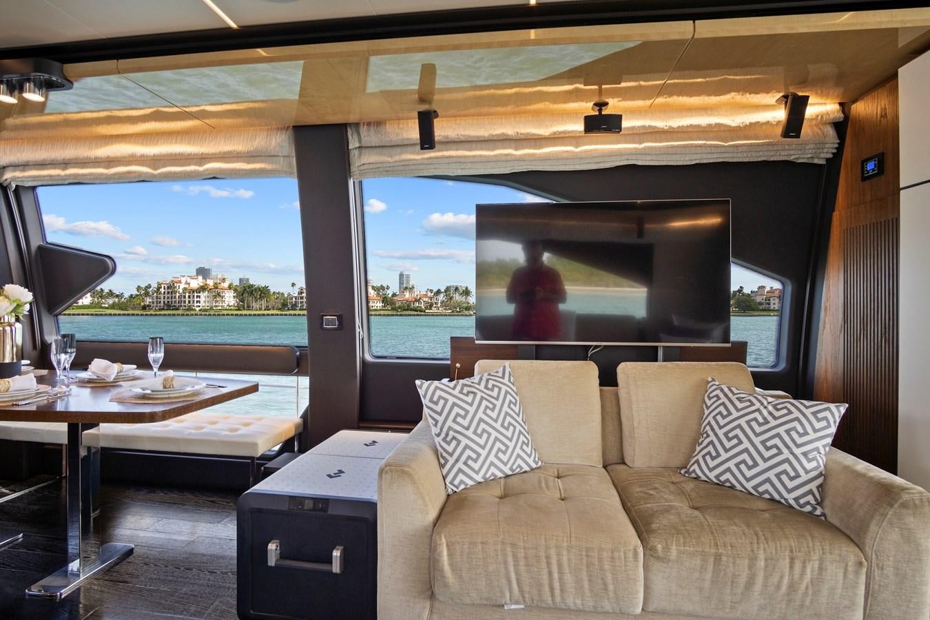 a couch and a table in a room with a view of the water aboard GRATITUDE Yacht for Sale