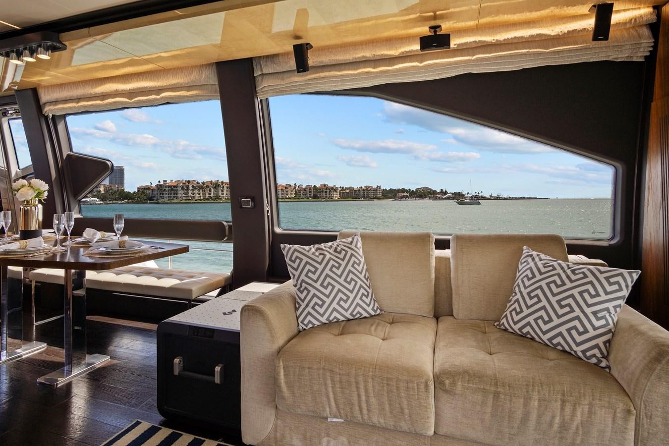 a couch and a table in a room with a view of the water aboard GRATITUDE Yacht for Sale