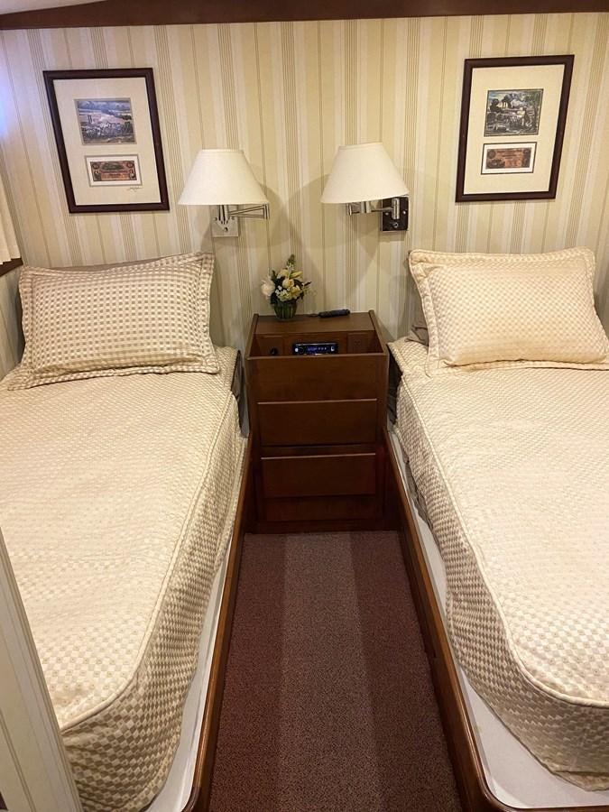 a bedroom with a bed and a lamp aboard VICTORY Yacht for Sale