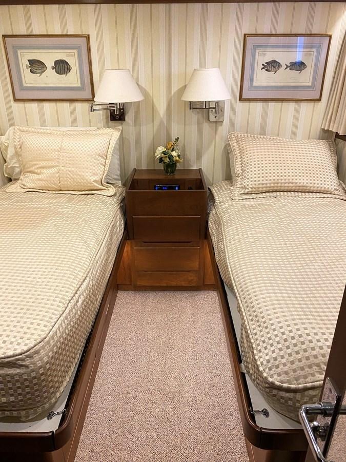 a bedroom with a bed and a dresser aboard VICTORY Yacht for Sale