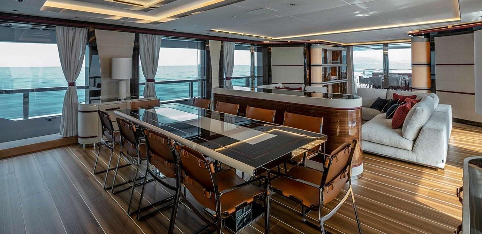 a large room with a table and chairs aboard EL LEON Yacht for Sale