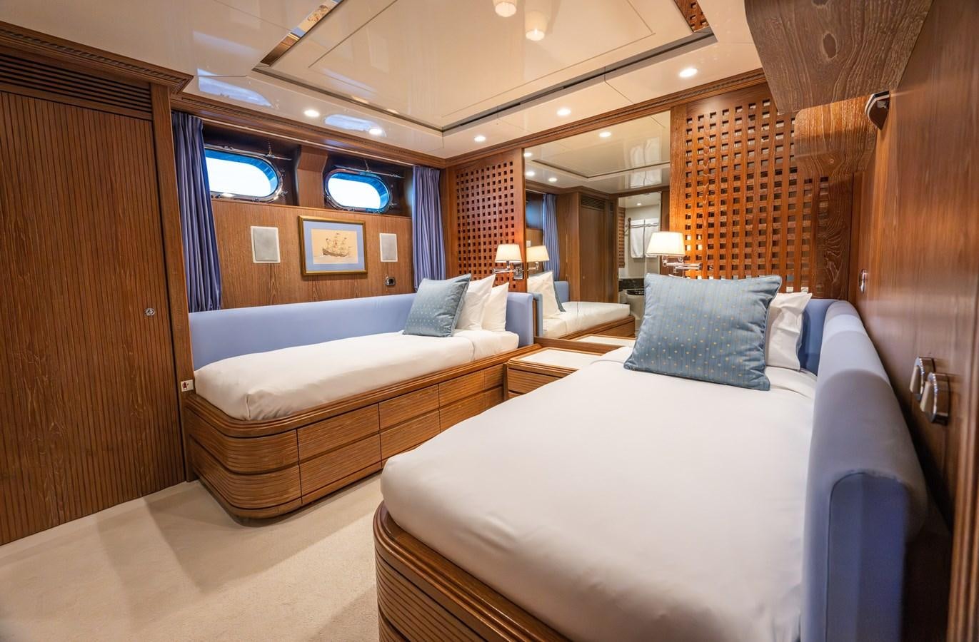 a hotel room with a bed and a large mirror aboard TAIPAN OF WALES Yacht for Sale