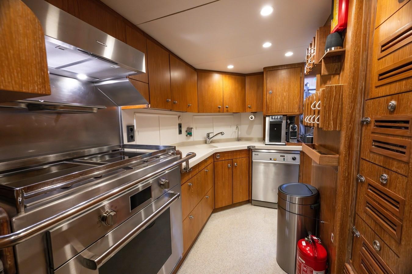 a kitchen with wooden cabinets aboard TAIPAN OF WALES Yacht for Sale