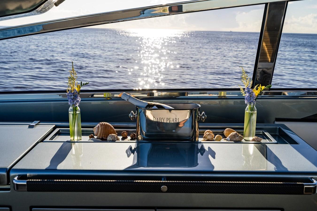 a boat with a flower vase and sunglasses on the front aboard 2021 RIVA 76' BAHAMAS Yacht for Sale