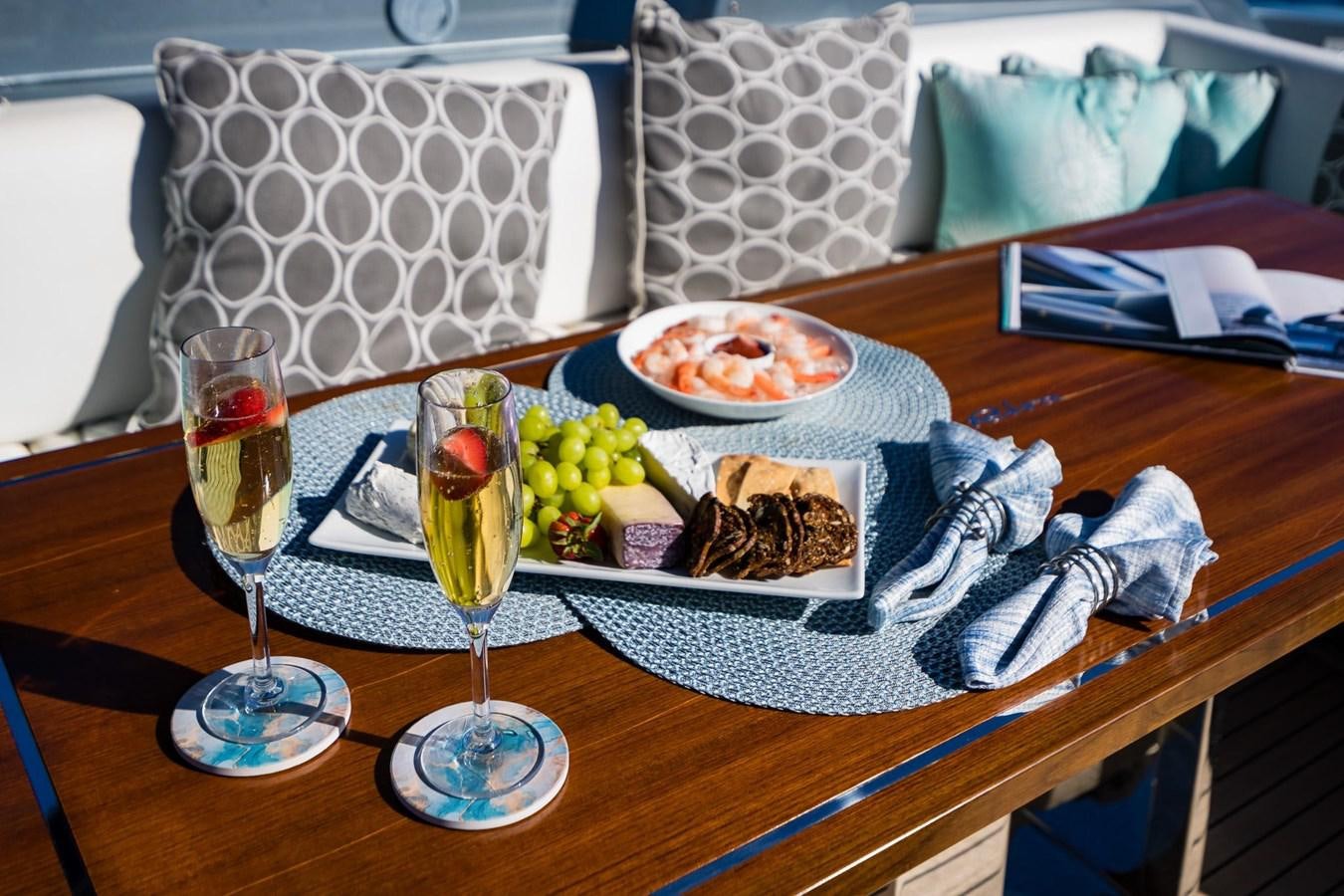 a table with food and drinks aboard 2021 RIVA 76' BAHAMAS Yacht for Sale