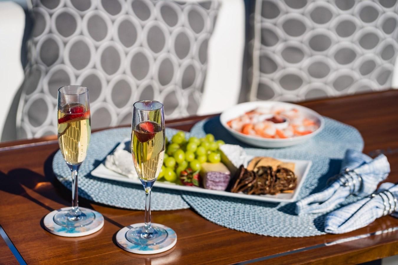 a table with food and drinks on it aboard 2021 RIVA 76' BAHAMAS Yacht for Sale