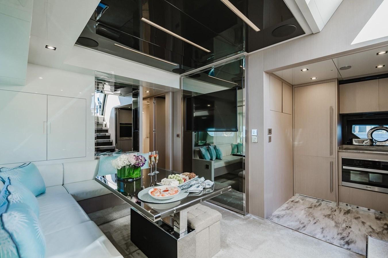 a living room with a bed and a table aboard 2021 RIVA 76' BAHAMAS Yacht for Sale