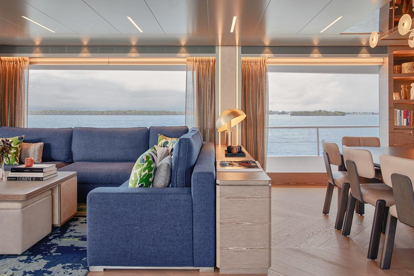 a living room with a blue couch aboard ASKARI Yacht for Sale