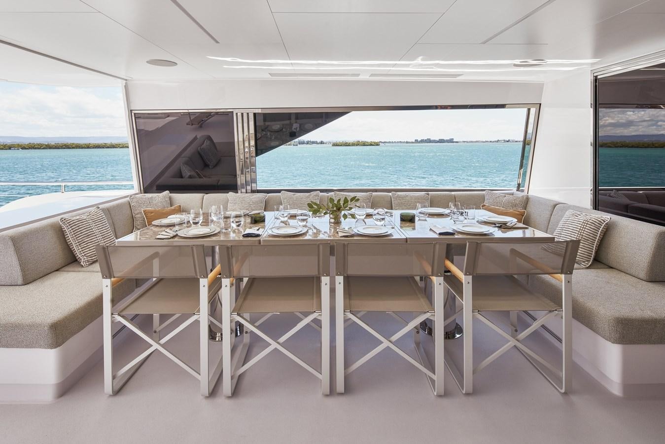 a table with chairs and a large window overlooking a body of water aboard ASKARI Yacht for Sale