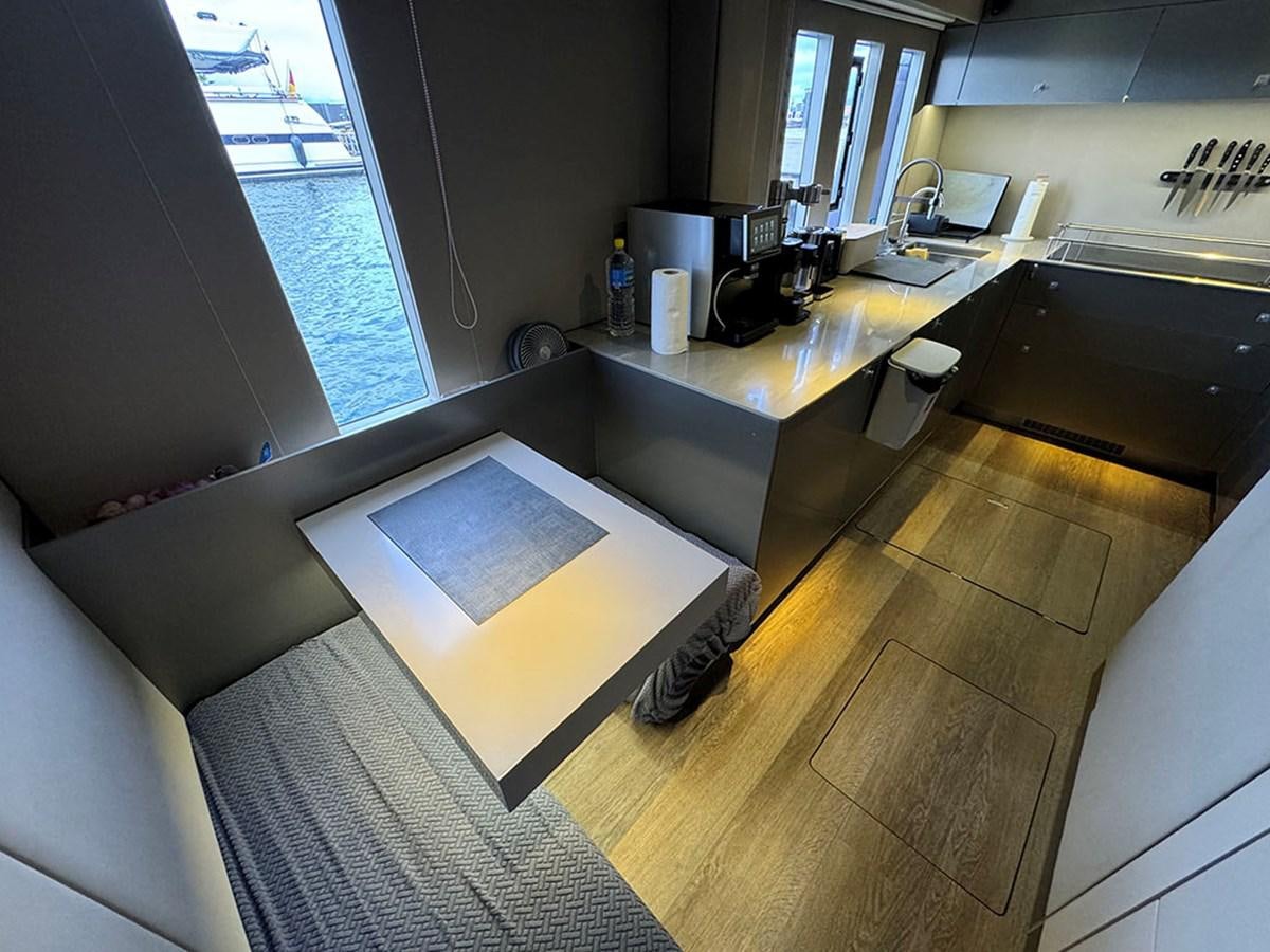 a kitchen with a table and a window aboard NAOMA Yacht for Sale