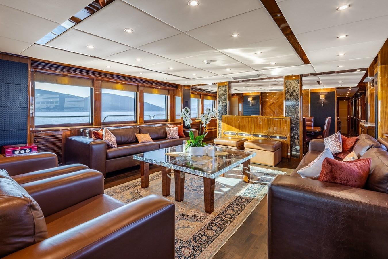 a living room with leather couches and a coffee table aboard IMAN Yacht for Sale