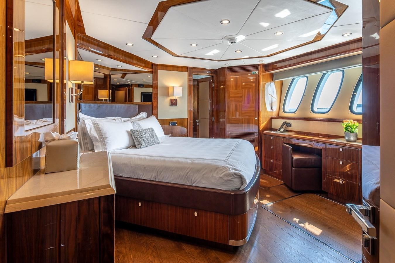 a bedroom with a bed and a desk aboard IMAN Yacht for Sale