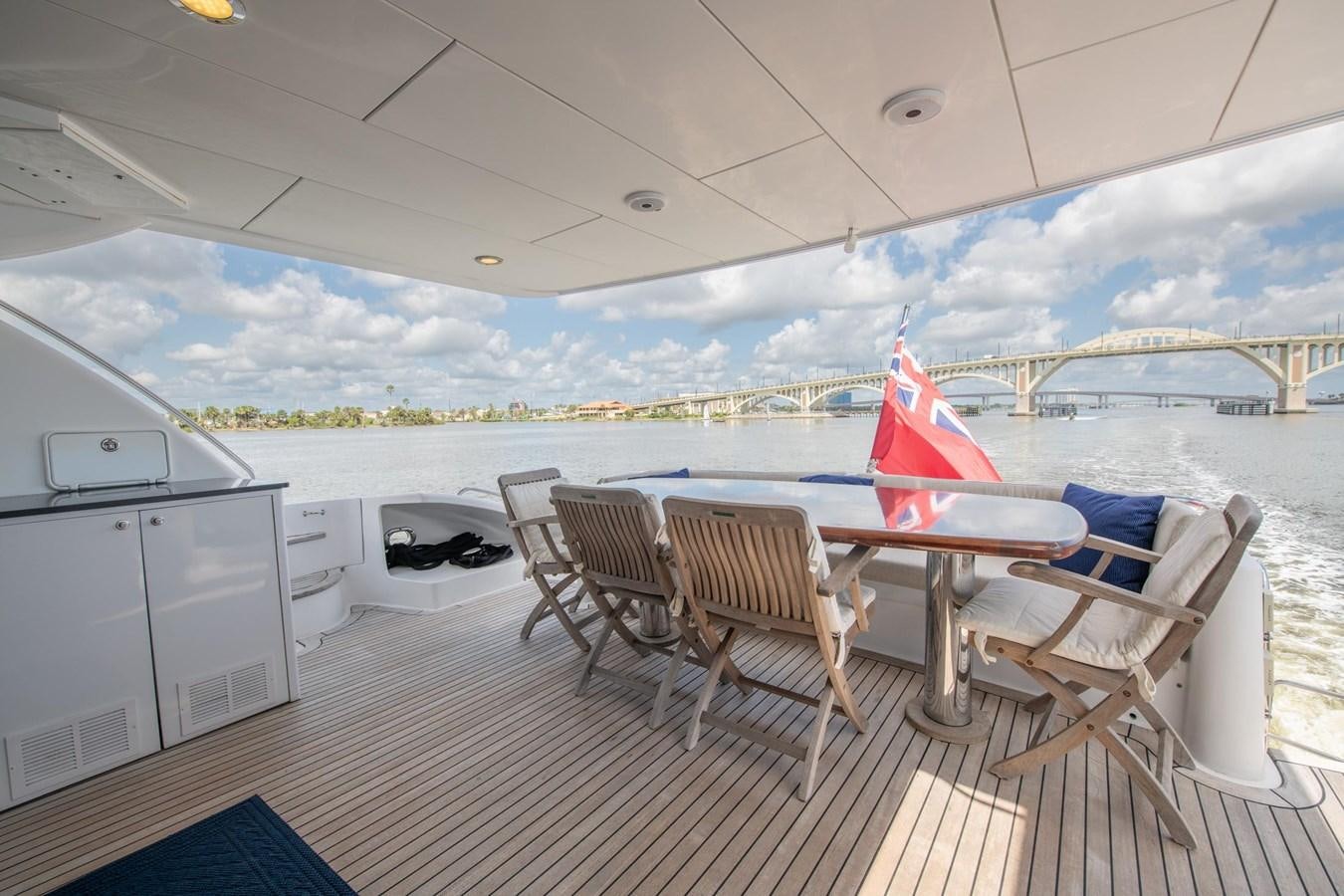 a deck with a table and chairs on it aboard DESTINY IV Yacht for Sale