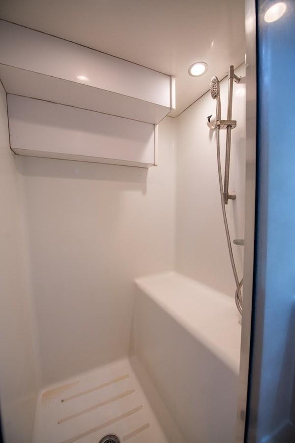a white bathroom with a shower head aboard DESTINY IV Yacht for Sale