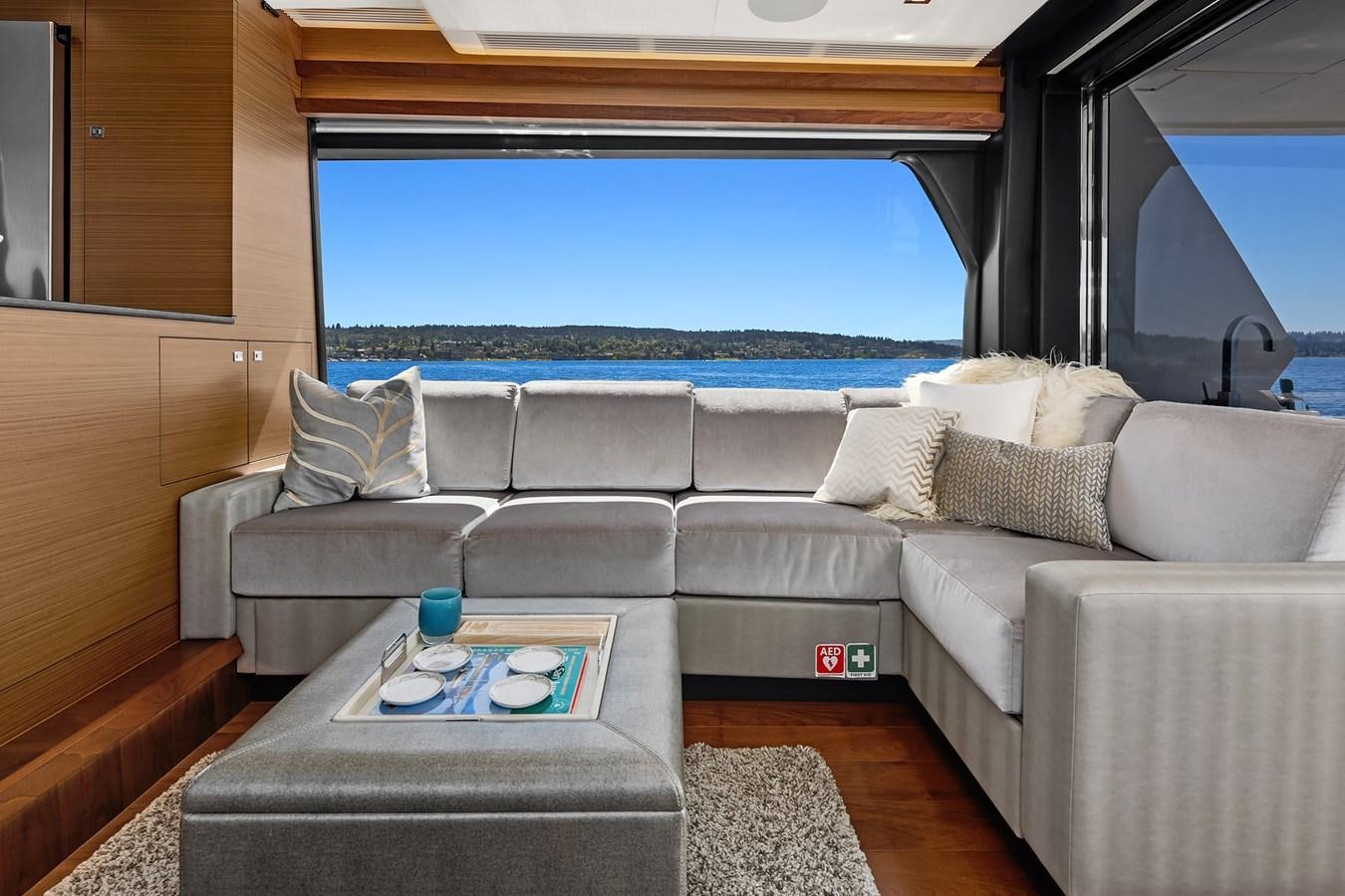 a couch with a table and a window aboard THRU & THRU Yacht for Sale