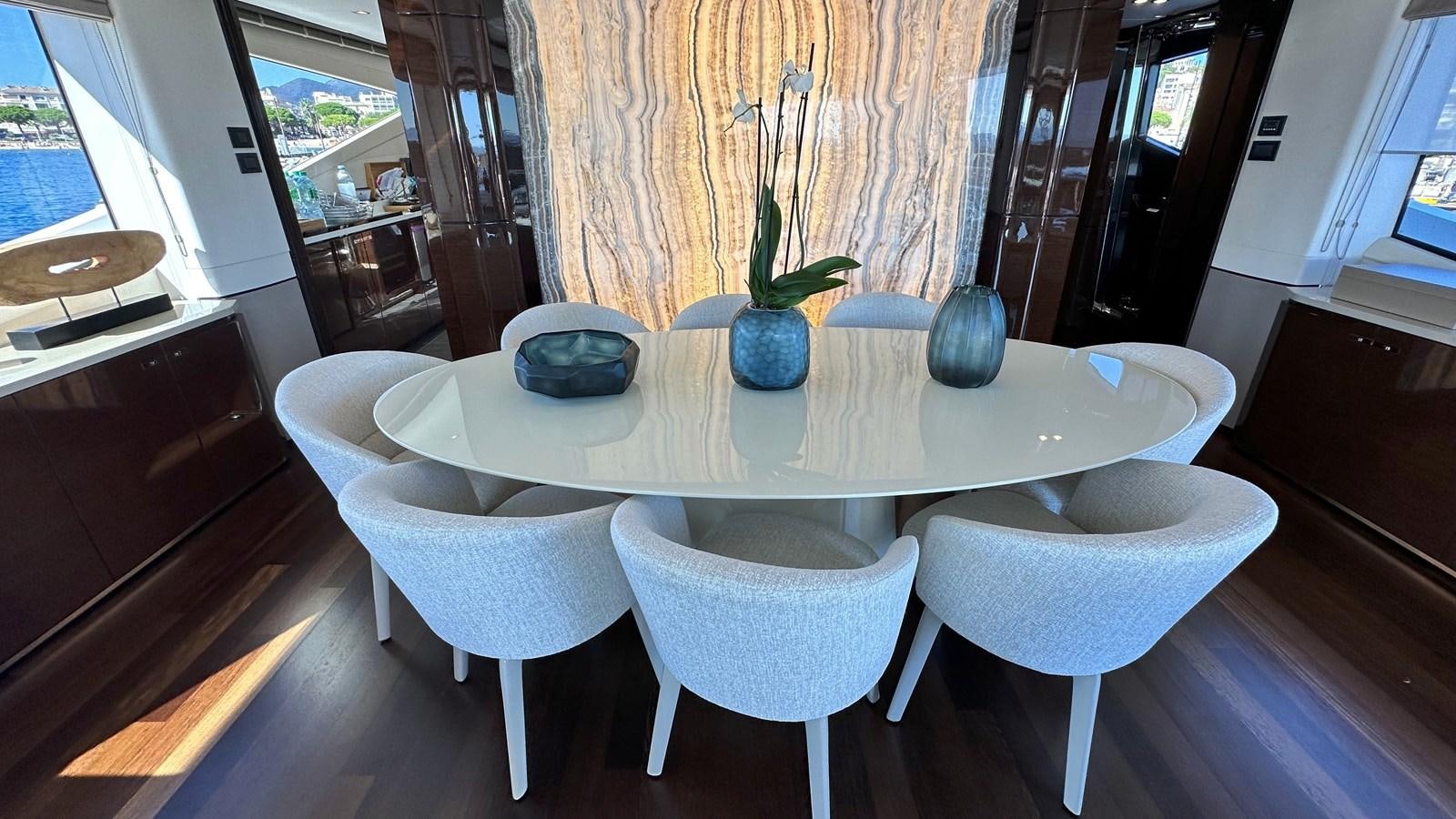 a table with white chairs and blue vases on it aboard GHOST Yacht for Sale