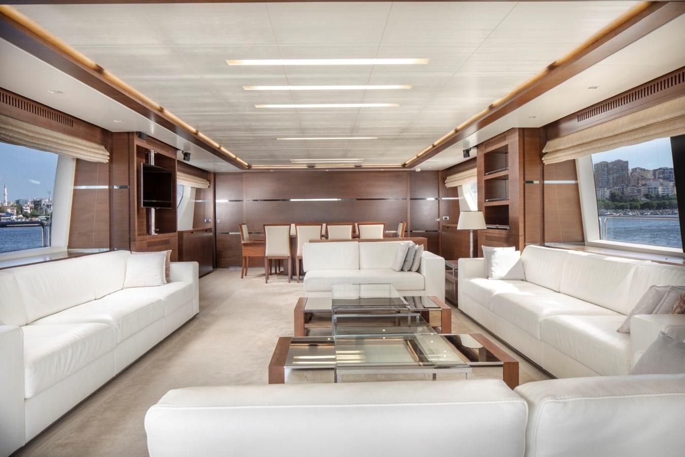 a living room with a large white sofa and a coffee table aboard NIMIR Yacht for Sale