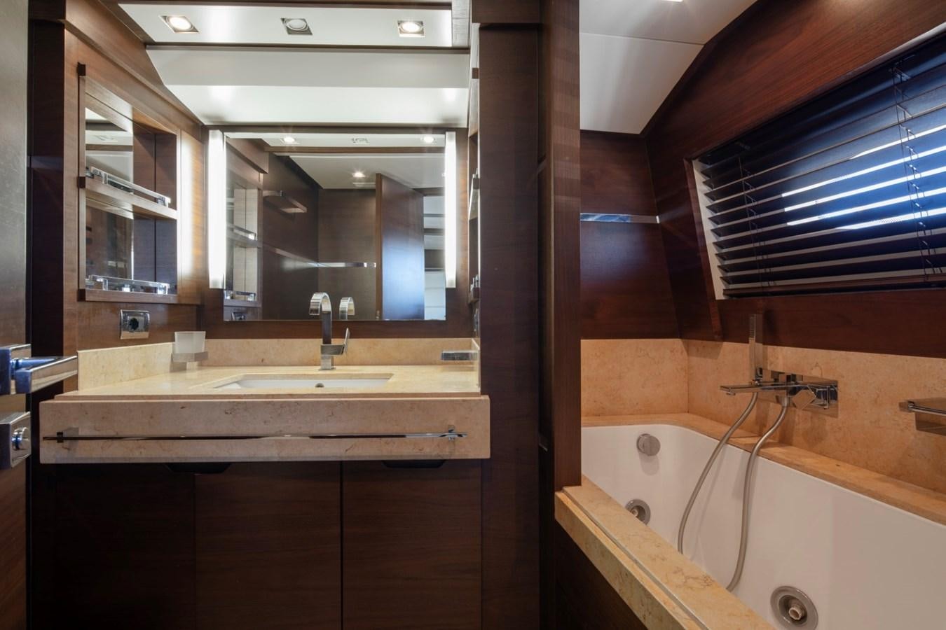 a bathroom with a bathtub and sinks aboard NIMIR Yacht for Sale