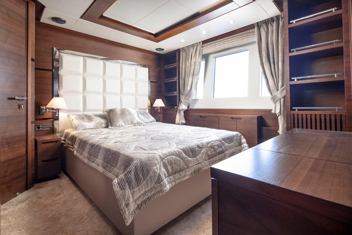 a bedroom with a bed and desk aboard NIMIR Yacht for Sale