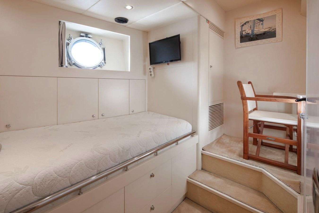 a room with a bed and a television on the wall aboard NIMIR Yacht for Sale