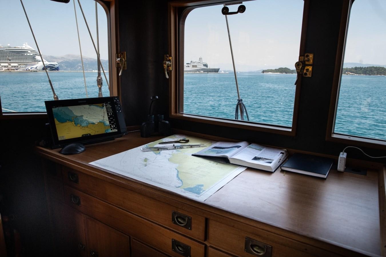 a desk with a laptop and a window aboard CASSIOPEIA Yacht for Sale