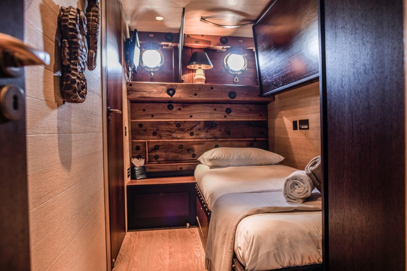 a bedroom with a bed and a dresser aboard CASSIOPEIA Yacht for Sale