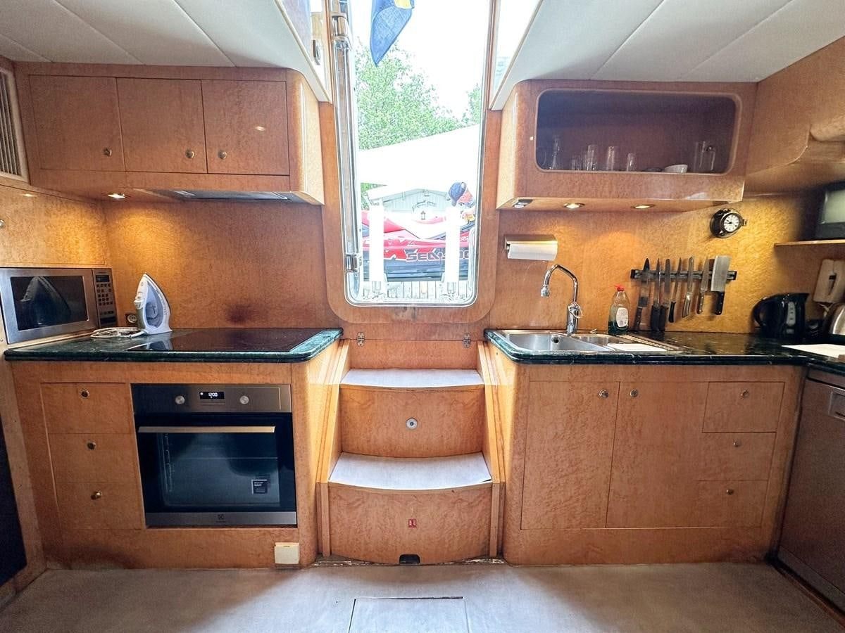 a kitchen with wooden cabinets aboard MALARPRINSESSAN Yacht for Sale