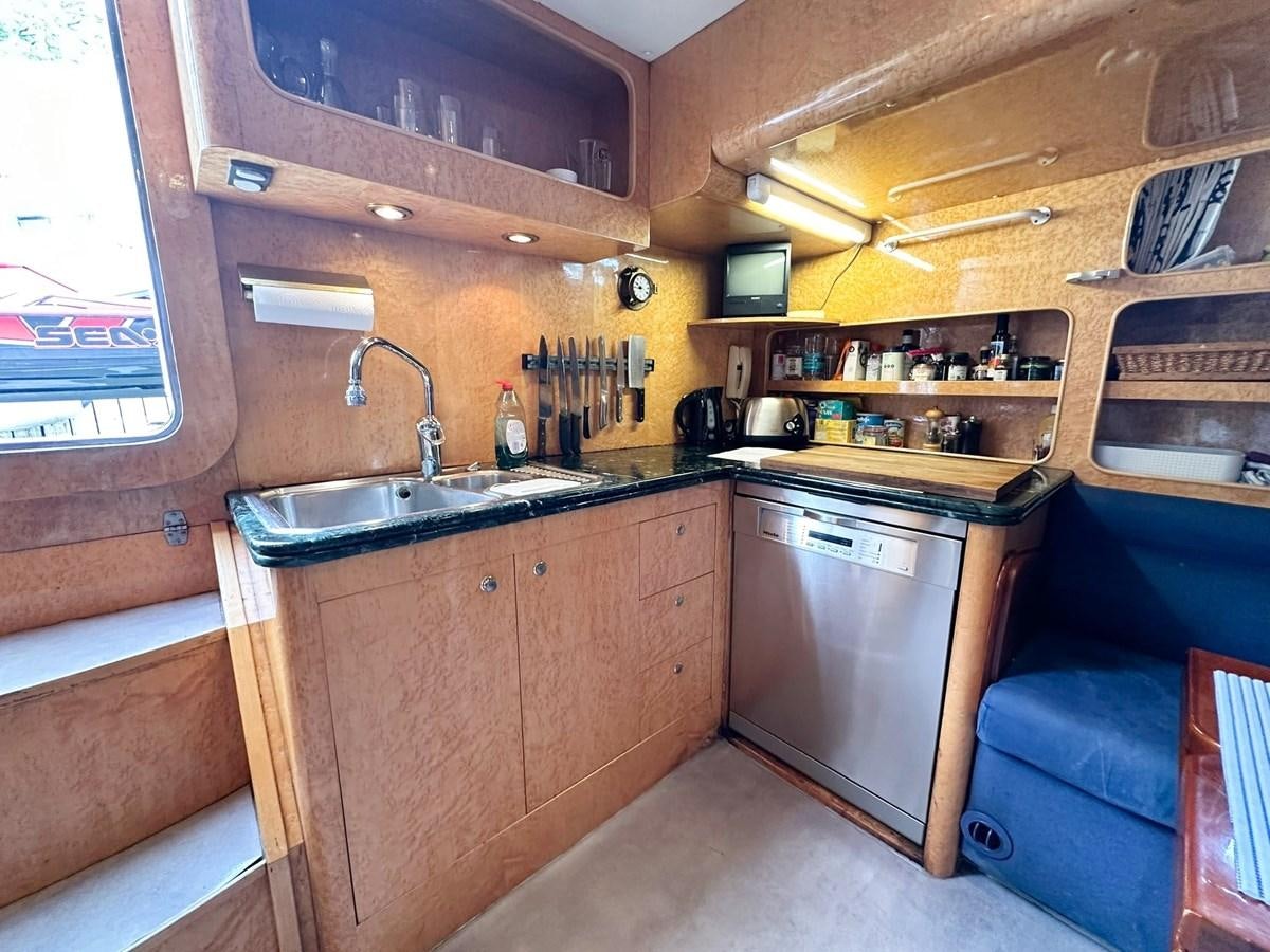 a kitchen with wooden cabinets aboard MALARPRINSESSAN Yacht for Sale