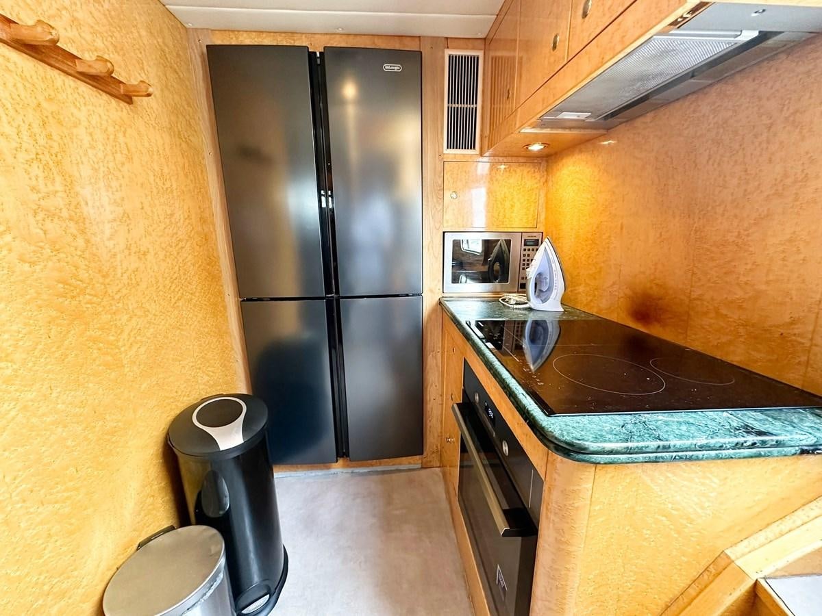a kitchen with black appliances aboard MALARPRINSESSAN Yacht for Sale