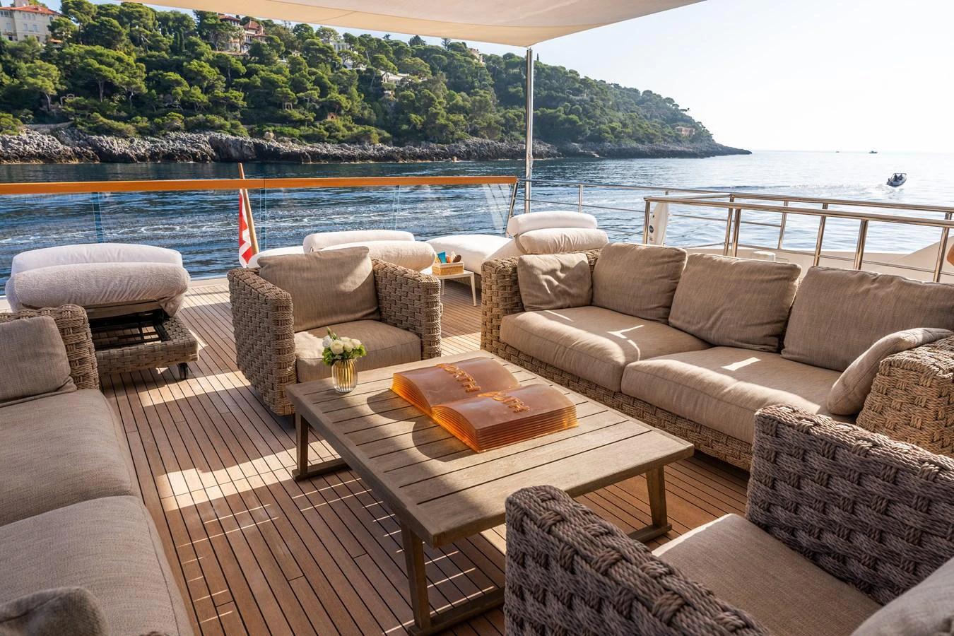 a couch and a table on a deck overlooking a body of water aboard BLUES Yacht for Sale