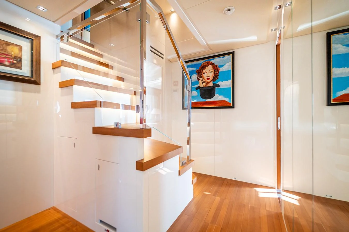 a staircase in a room with paintings on the wall aboard BLUES Yacht for Sale
