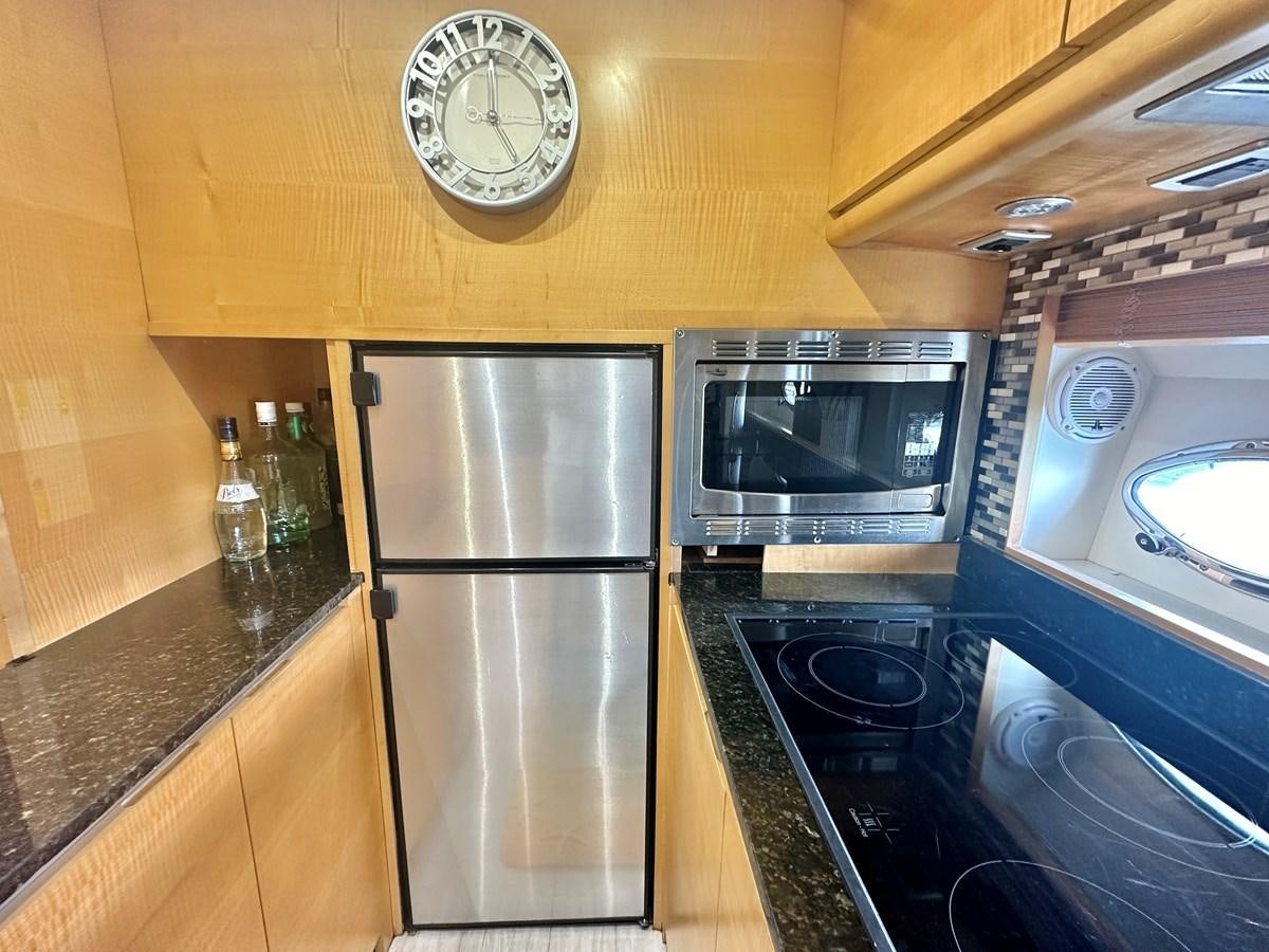 a kitchen with a stainless steel refrigerator aboard NOTORIUS Yacht for Sale