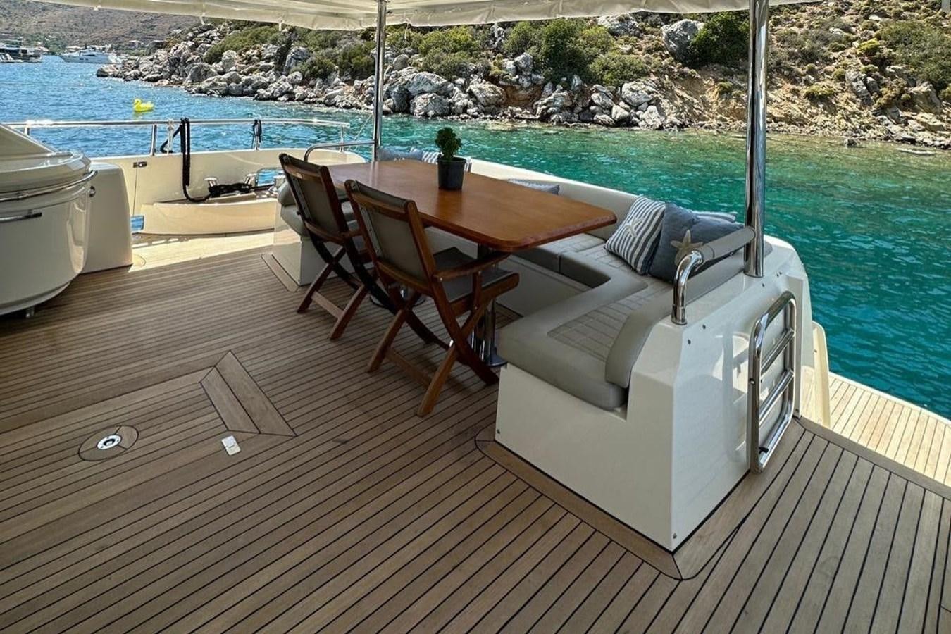 a deck with a table and chairs on it aboard AZIMUT 84/12 Yacht for Sale