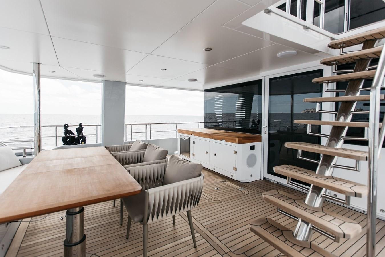 a room with a couch and a table and a bench aboard BERING 76  LEMANJA Yacht for Sale