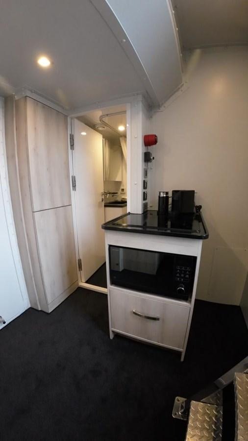 a kitchen with a stove and a microwave aboard BERING 76  LEMANJA Yacht for Sale