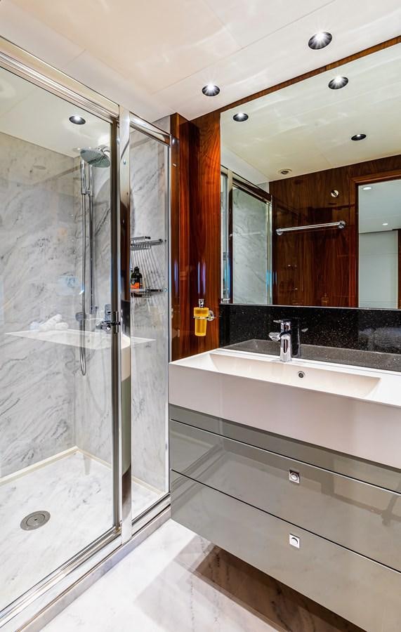 a bathroom with a glass shower aboard KUDOS Yacht for Sale