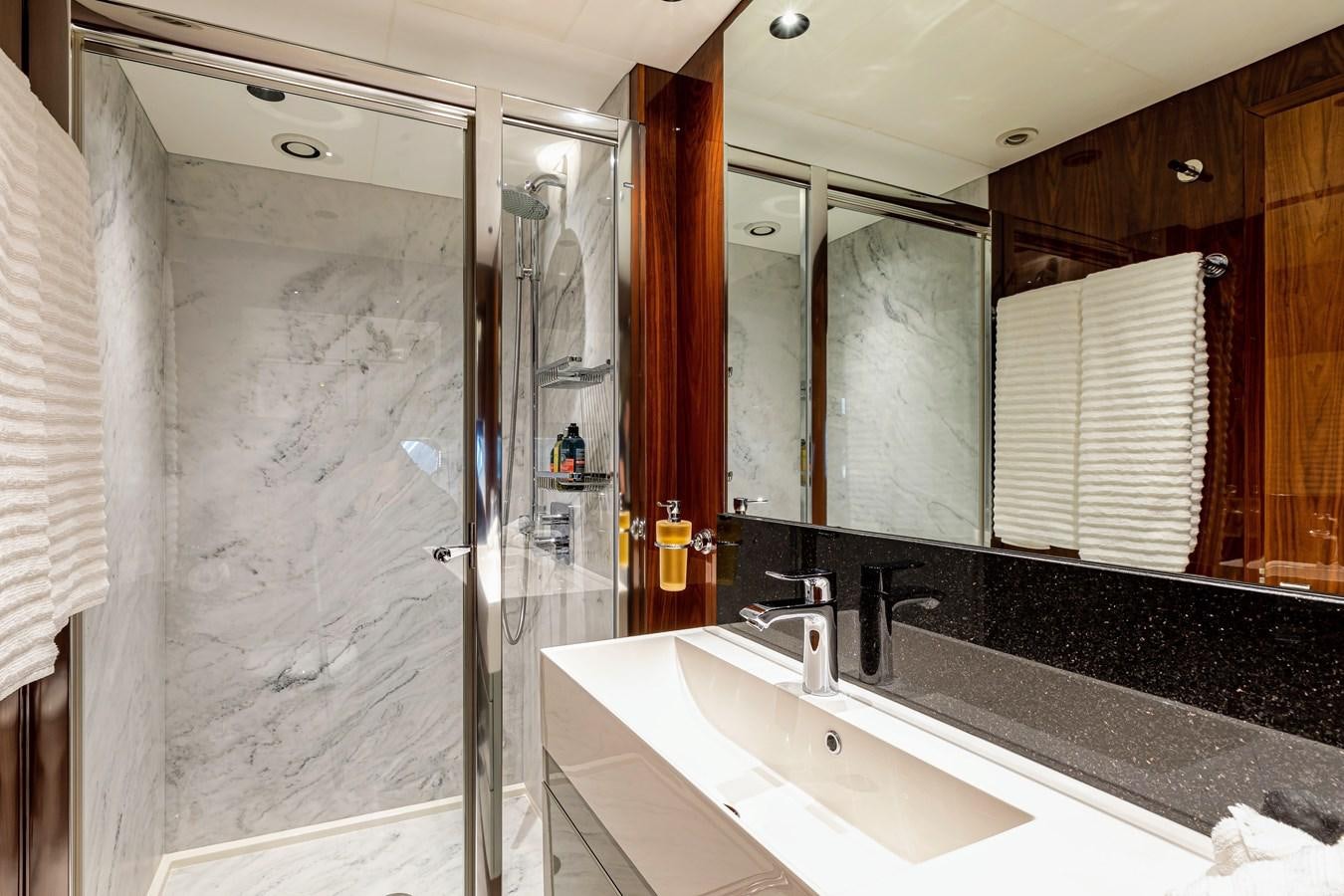 a bathroom with a glass shower aboard KUDOS Yacht for Sale