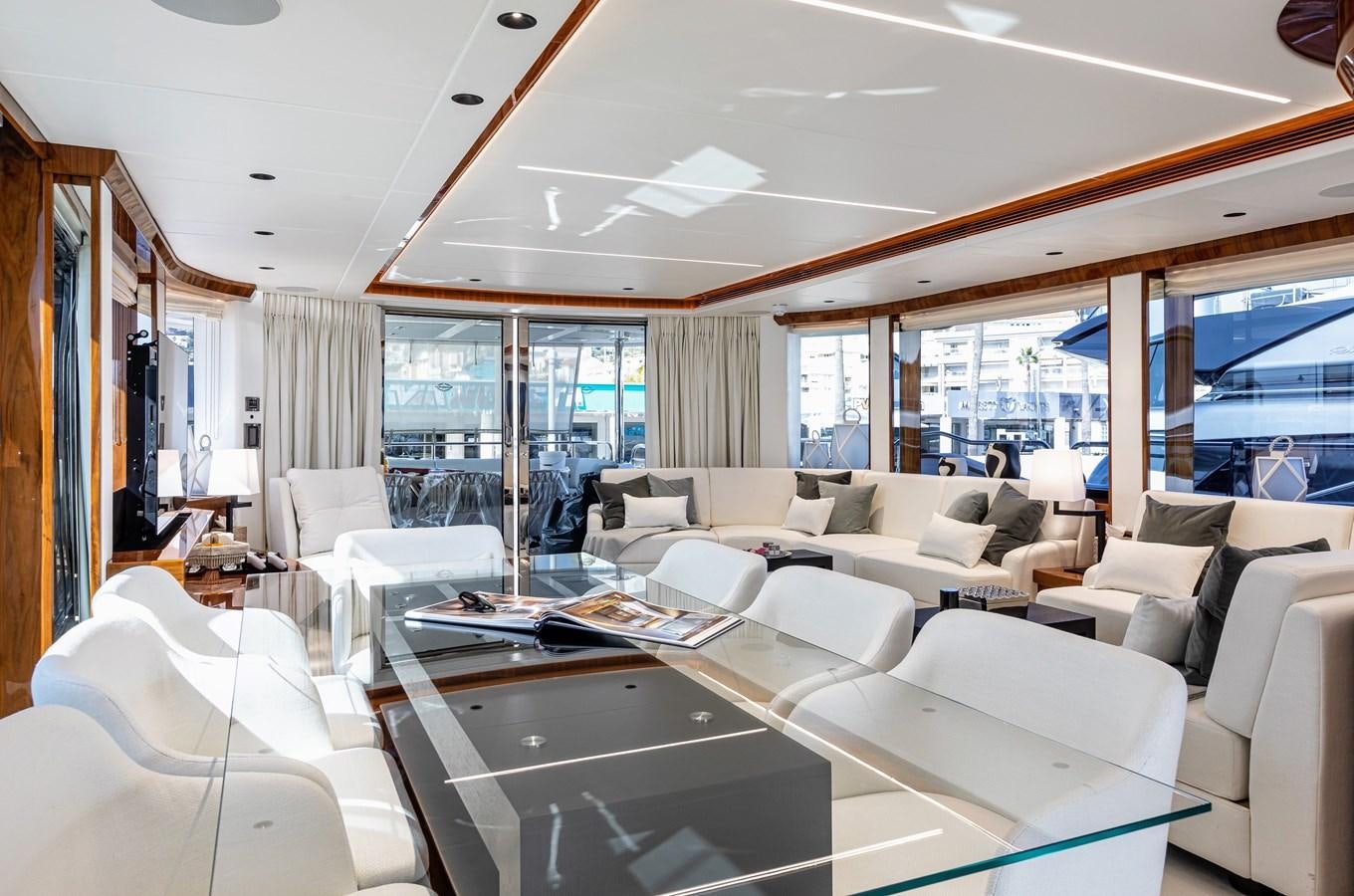 a large room with white couches and a large window aboard KUDOS Yacht for Sale